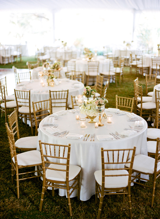 Elegant outdoor wedding reception tables with gold chairs