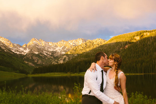 Couple kissing with a mountain backdrop, scenic wedding