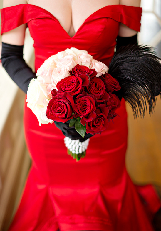 red and white rose bouquet with black feathers
