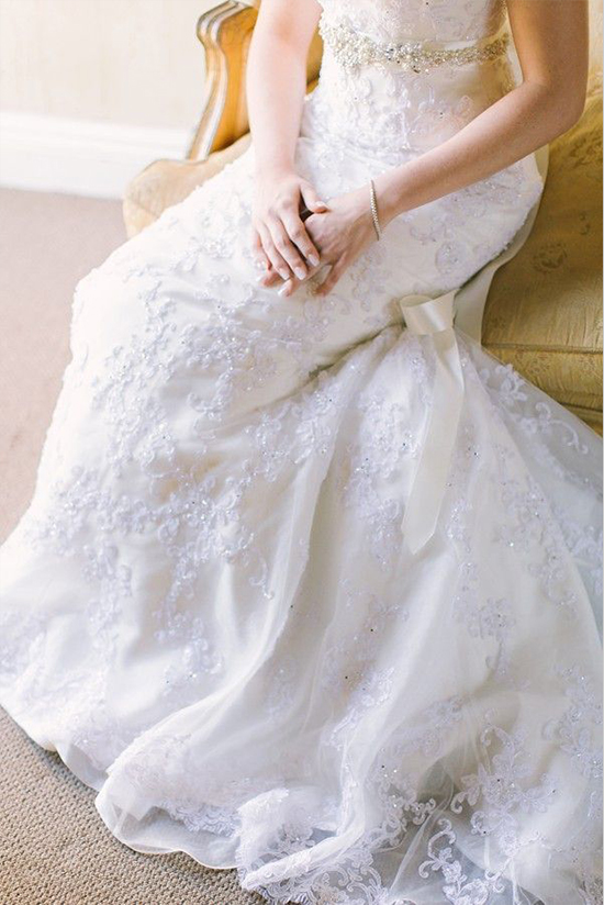 Elegant bride in a detailed white wedding dress with lace and jewels