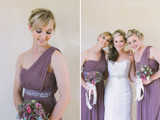Bridesmaids in plum dresses pose with the bride on a wedding day