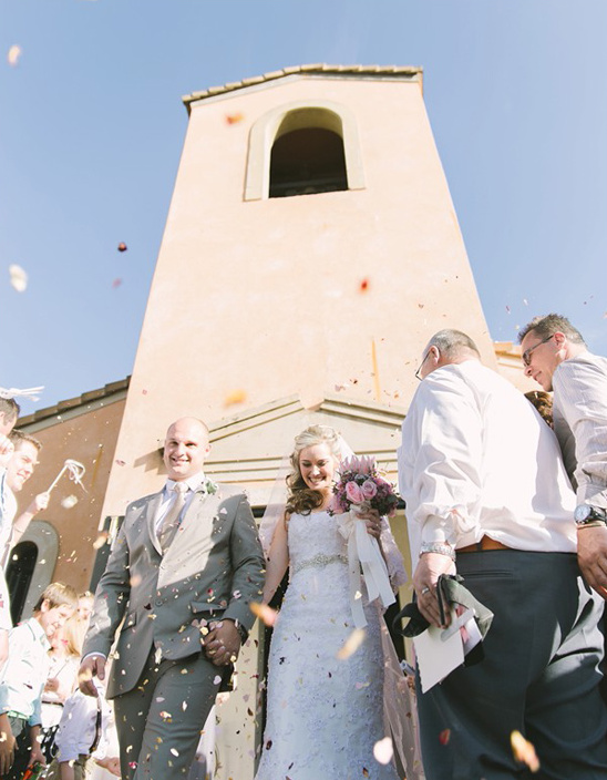 Newlyweds walk through confetti after their wedding ceremony