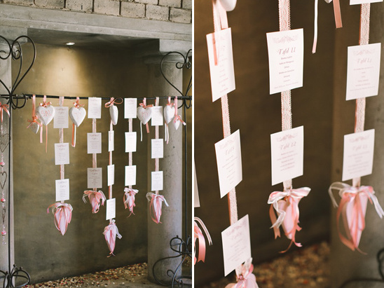 Elegant wedding seating chart with hearts and pink ribbons