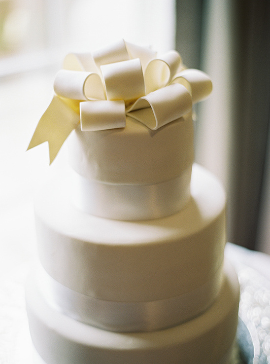 white wedding cake with bow on top