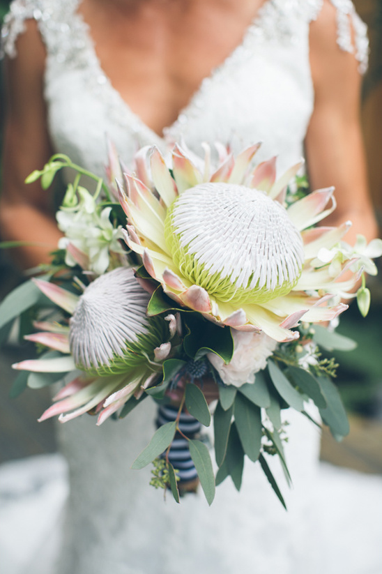 Bride holding a beautiful protea flower bouquet at her wedding