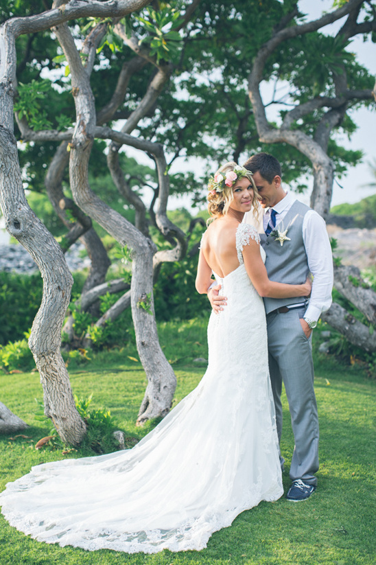 Bride and groom embrace outdoors on their wedding day with trees