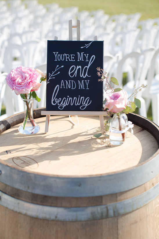 Wedding sign with romantic quote and flowers on a barrel