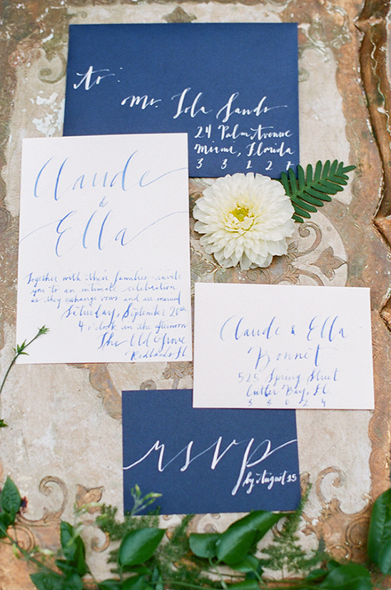 Elegant wedding invitation with blue calligraphy and flowers