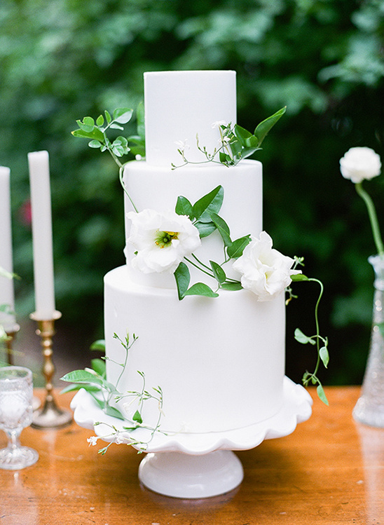 Elegant white wedding cake decorated with fresh flowers