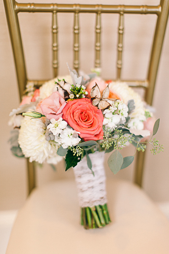 Elegant wedding bouquet with coral roses and butterfly details