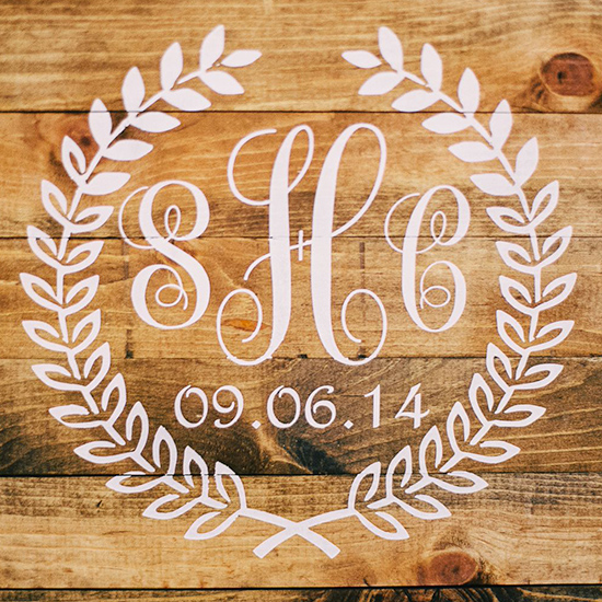 Wedding monogram on wooden board with floral wreath