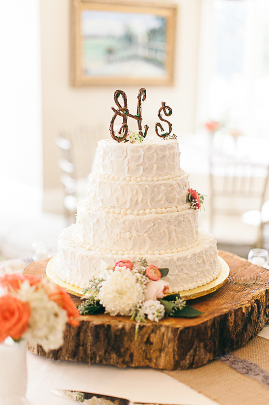 Elegant white wedding cake with floral accents and HS initials