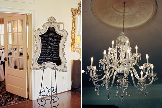 Elegant wedding decor featuring a chandelier and a seating chart
