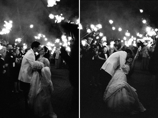 Romantic black and white wedding photo with sparklers and a kiss