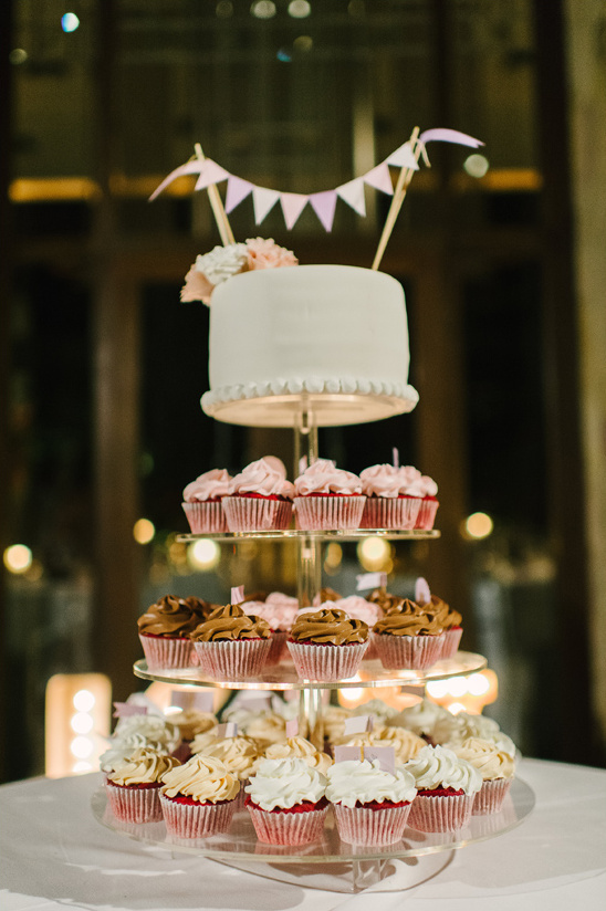 cupcake tower topped with a wedding cake @weddingchicks