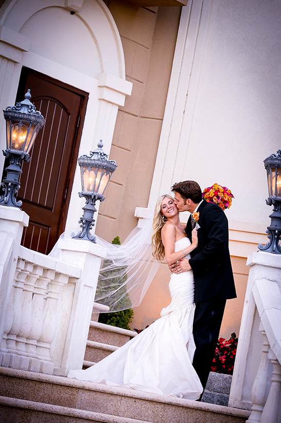Happy couple's wedding day kiss on stairs