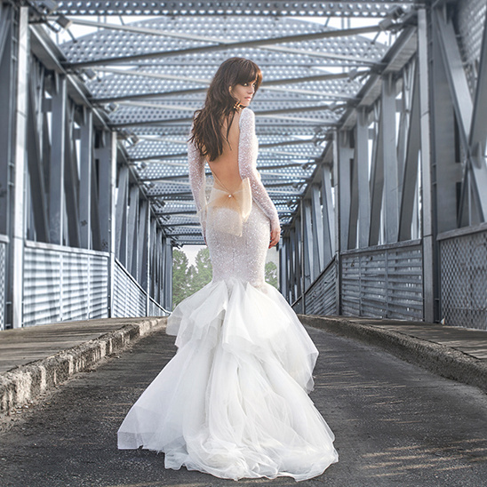 Elegant bride in a white wedding dress posing on the bridge