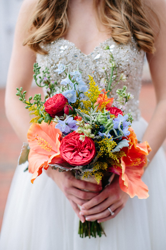 Vibrant bridal bouquet with red, orange, and blue flowers
