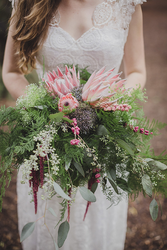 Bride holding rustic wedding bouquet of protea flowers