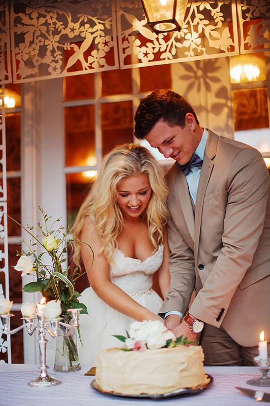 Bride and groom cutting their wedding cake together at reception