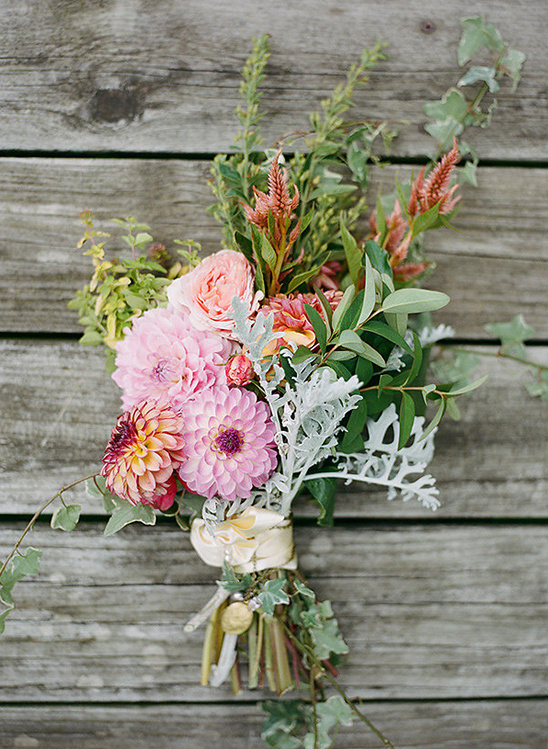 Elegant floral bouquet with pink and orange flowers on wood background