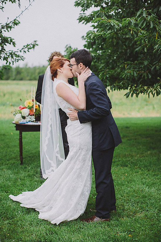Newly married couple sharing their first kiss at their wedding