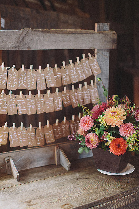 Rustic wedding seating chart with name tags and floral arrangement