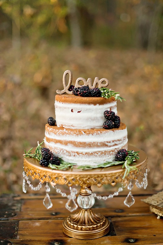 Two-tiered rustic wedding cake with blackberries and love topper