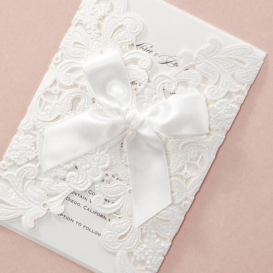 Elegant wedding invitation with lace design and a satin bow