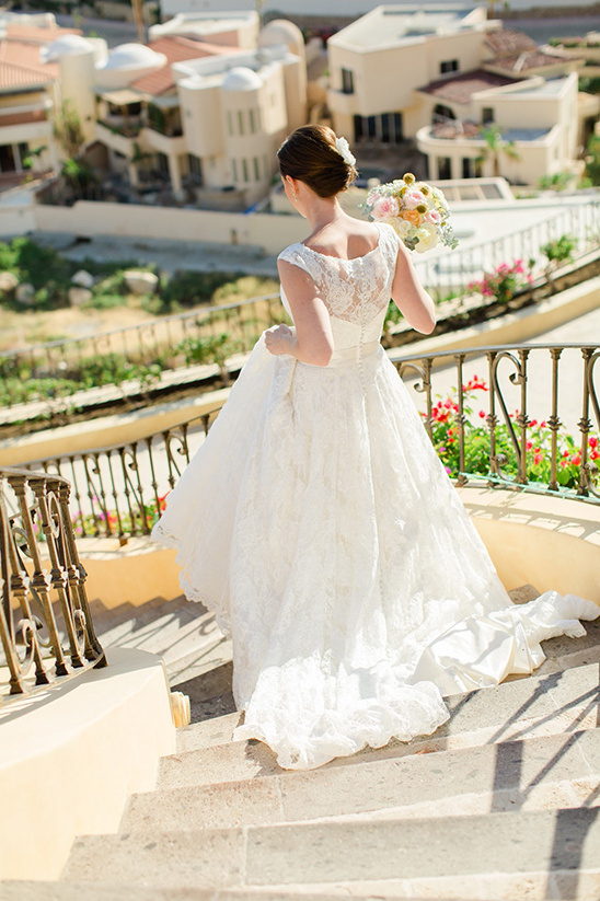 Bride in a white wedding dress walks down the stairs