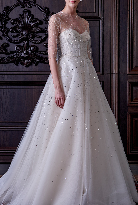 Elegant bride in sparkling wedding dress with sheer sleeves