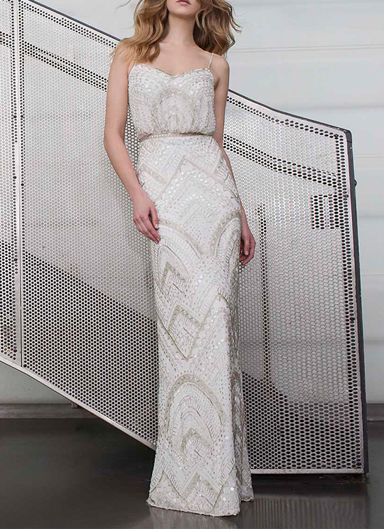 Elegant beaded wedding dress with spaghetti straps on a model