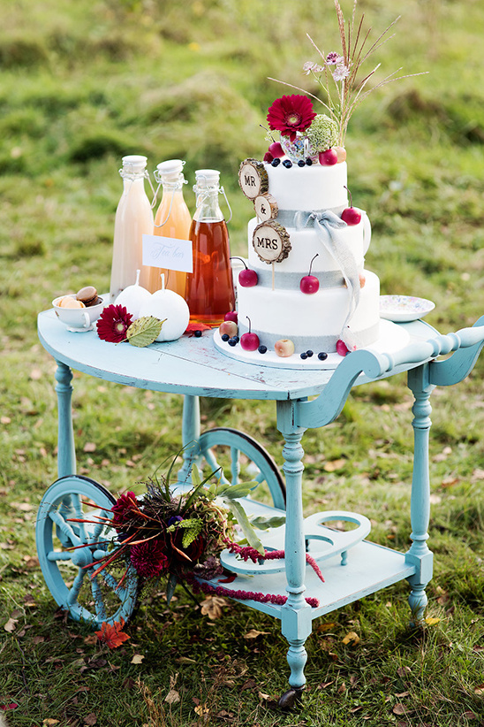 Wedding cake on vintage teal cart with drinks and decor