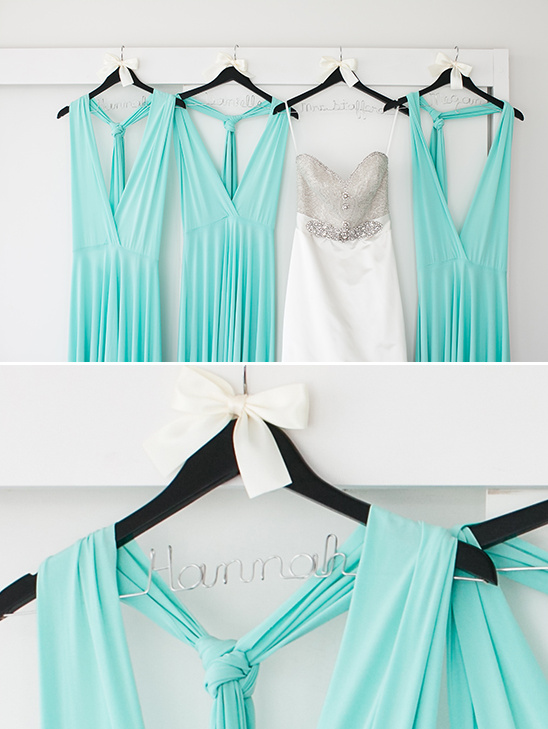 Mint bridesmaid dresses and wedding gown on hangers