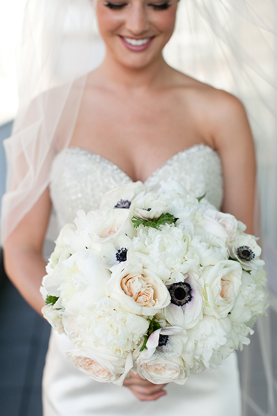 Bride holding a beautiful white wedding bouquet with a smile