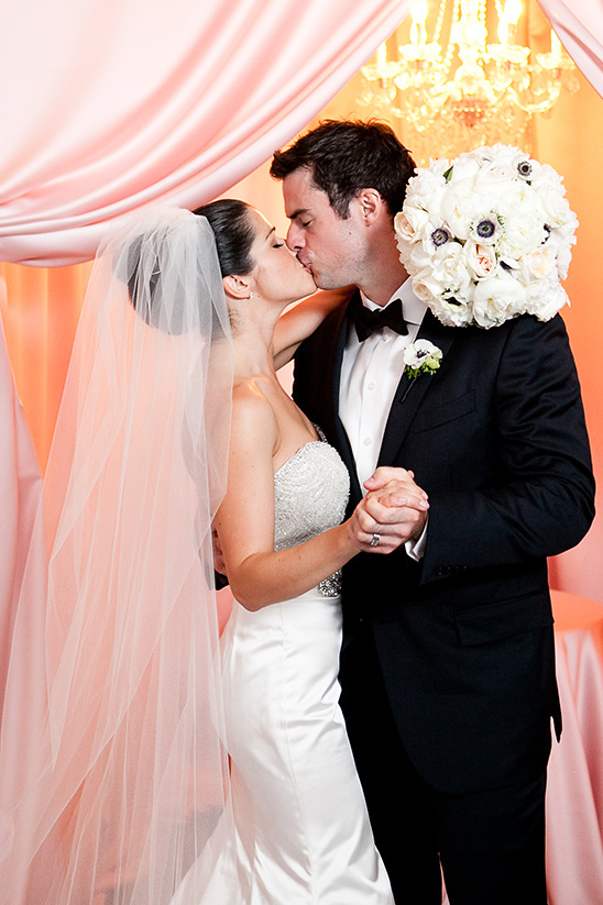 Elegant bride and groom sharing a tender kiss at their wedding