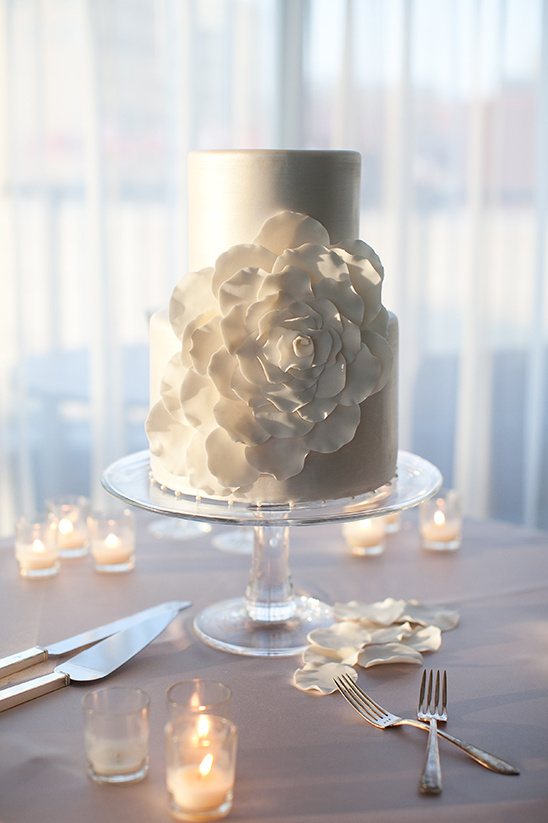 Elegant wedding cake with flower detail on glass stand