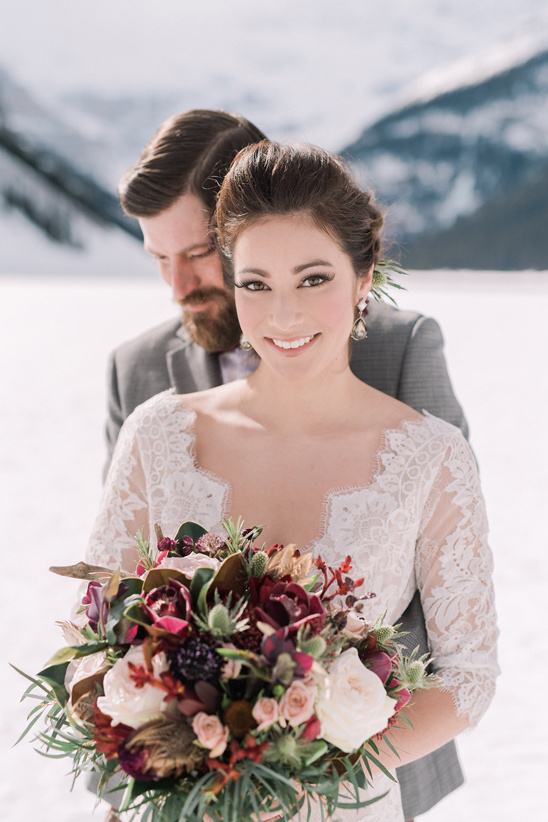 Bride and groom winter wedding portrait with bouquet