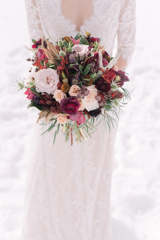 Elegant bride with a rustic bouquet of flowers and antlers