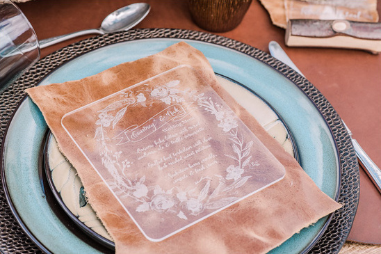 Elegant wedding place setting with menu on a clear plate