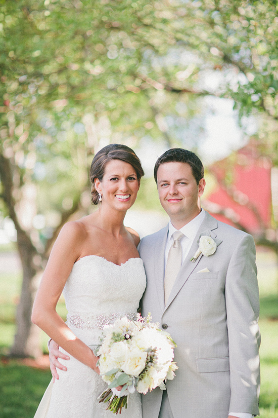 Happy couple smiling at their wedding, outdoors under a tree