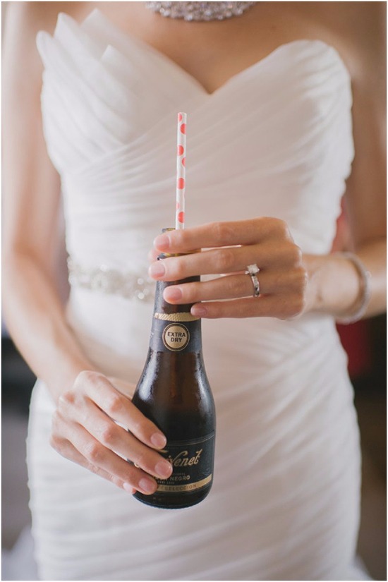 Bride holding a drink with a polka dot straw during a wedding
