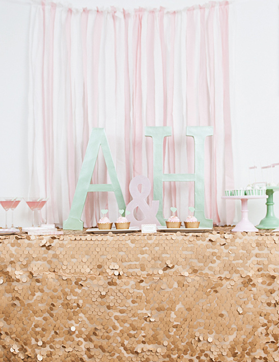 Elegant gold sequin table decor with initials and cupcakes