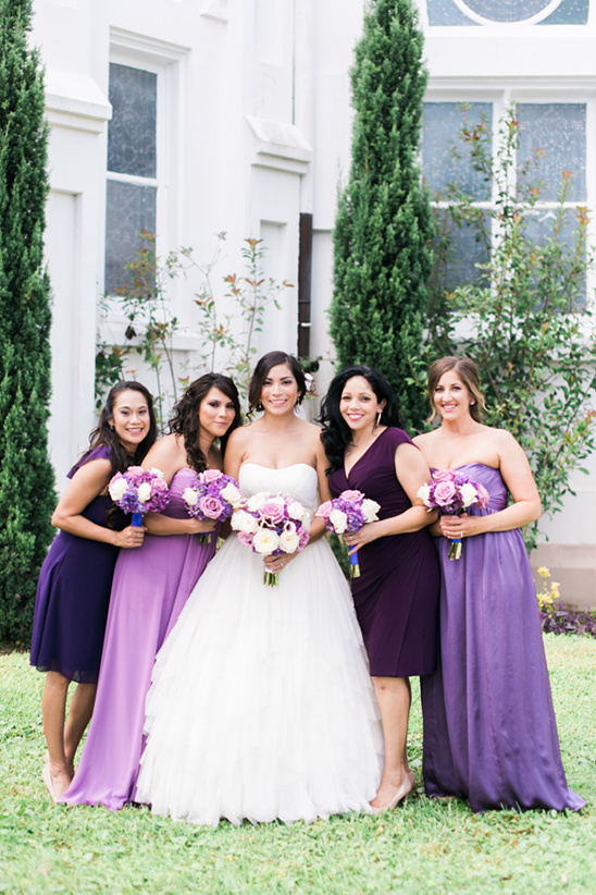 Bride and bridesmaids in purple dresses with bouquets