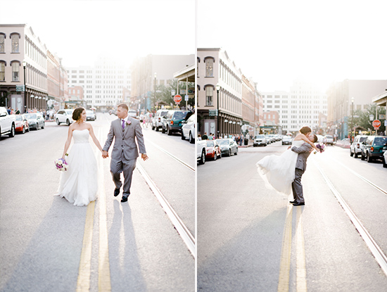 Wedding couple holding hands and being embraced in a city street