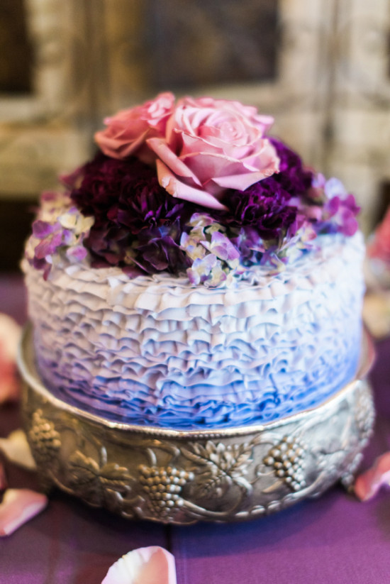 A beautiful wedding cake with flowers, purple and blue ombre frosting