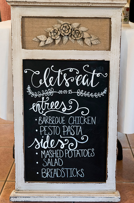 Rustic wedding menu board with floral decorations and chalk lettering