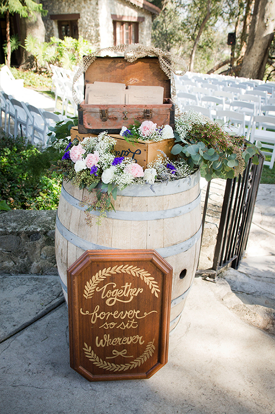 Wedding ceremony decor with barrels, flowers and a wooden sign