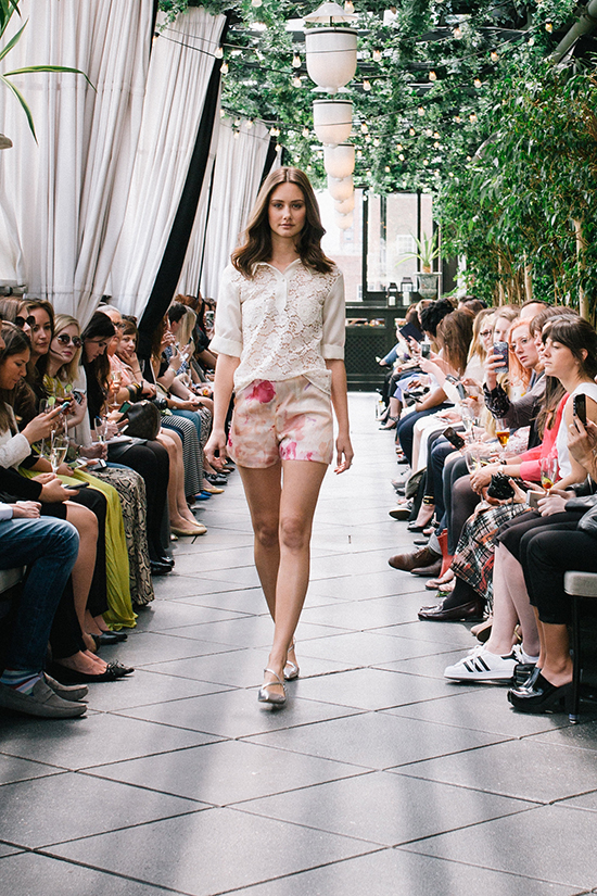 Model walking the runway during a fashion show with audience
