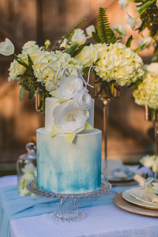 Elegant two-tier wedding cake with blue ombre and flower decor